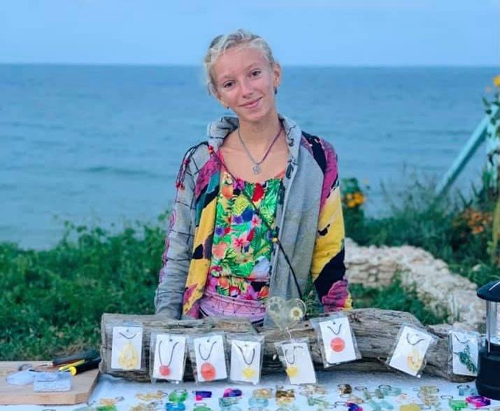 O fetiță de 11 ani vinde accesorii handmade, pe faleza din Vama Veche, pentru a-și opera cățelul paralizat