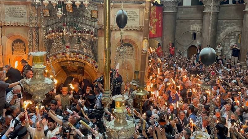 (FOTO/VIDEO) Lumina Sfântă a fost împărțită în Biserica Sfântului Mormânt din Ierusalim. Când va ajunge și în România