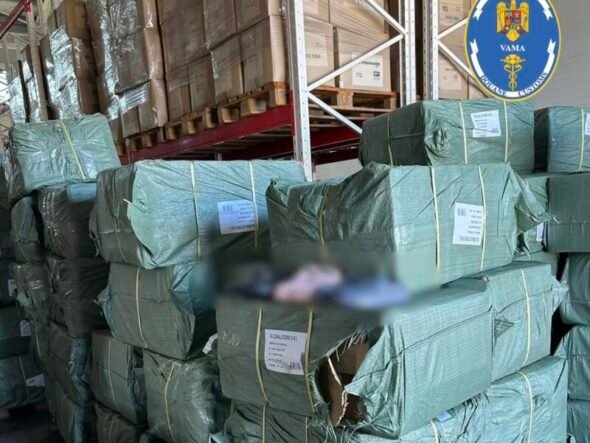 Stacks of green-wrapped bundles on wooden pallets in a warehouse, with a Romanian customs logo visible in the top right corner and labels on the bundles.