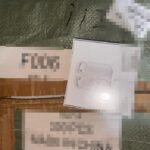 White AirPods box resting on brown cardboard packaging material on a shipping pallet area.