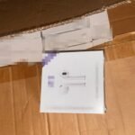 White box displaying AirPods packaging on a cardboard surface.