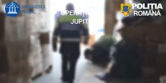 Blurred hallway scene with a uniformed officer walking away; Romanian police logos (Ministerul Public, Poliția Română) are visible in the frame, suggesting a police operation.