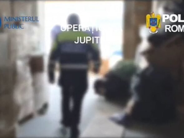Blurred hallway scene with a uniformed officer walking away; Romanian police logos (Ministerul Public, Poliția Română) are visible in the frame, suggesting a police operation.