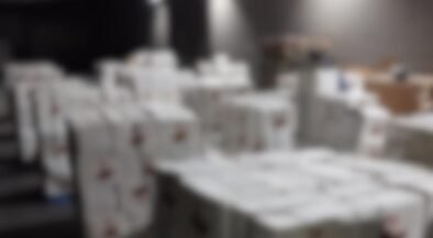 Blurred warehouse scene with stacked white boxes; DIICOT and Poliția Română logos appear in the top corners.
