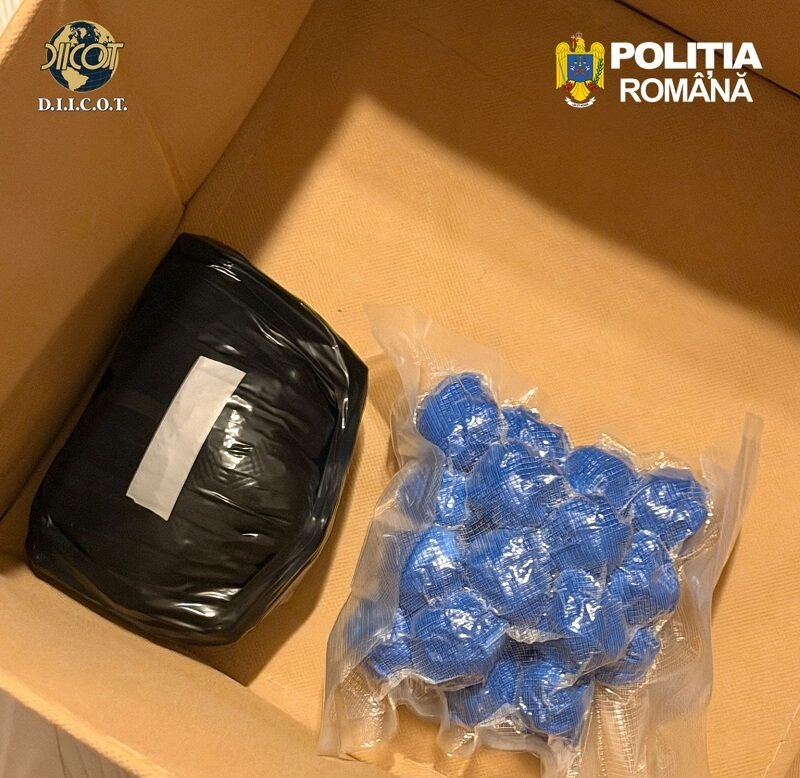 Box containing a black wrapped package and blue blister packs, with DIICOT and POLITIA ROMANA logos visible—likely seized items in a police evidence box.