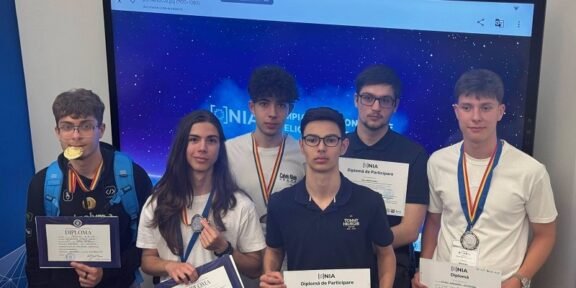 Six students pose with diplomas and medals after an awards ceremony, in front of a blue starry backdrop.
