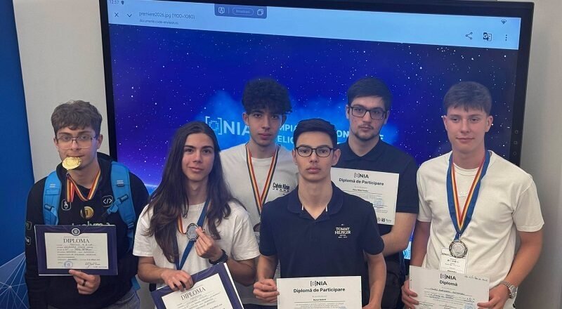 Six students pose with diplomas and medals after an awards ceremony, in front of a blue starry backdrop.