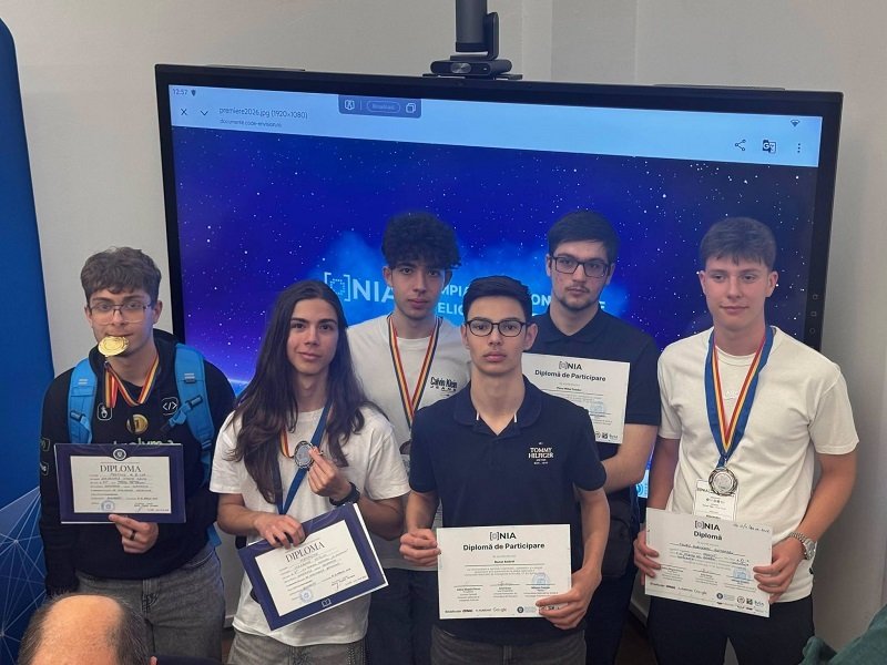 Six students pose with diplomas and medals after an awards ceremony, in front of a blue starry backdrop.