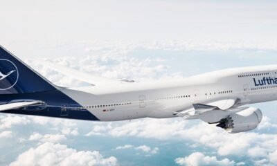 Lufthansa airliner flying above clouds, white fuselage with blue tail and Lufthansa logo