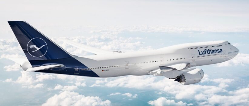Lufthansa airliner flying above clouds, white fuselage with blue tail and Lufthansa logo