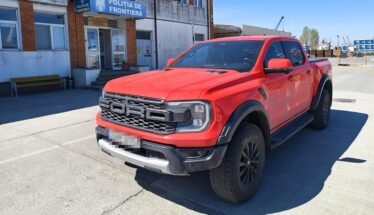 Red Ford Ranger pickup parked in front of a Romanian border police station (Politia de Frontiera) in a paved lot.