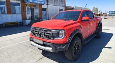 Red Ford Ranger pickup parked in front of a Romanian border police station (Politia de Frontiera) in a paved lot.