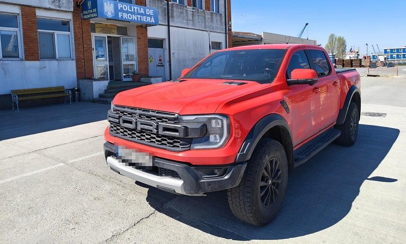 Red Ford Ranger pickup parked in front of a Romanian border police station (Politia de Frontiera) in a paved lot.