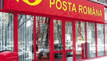 Front of a Poșta Română post office with a red facade, glass doors, and a red mailbox outside in the snow.