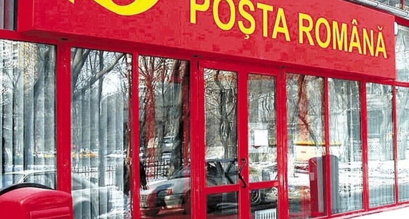 Front of a Poșta Română post office with a red facade, glass doors, and a red mailbox outside in the snow.