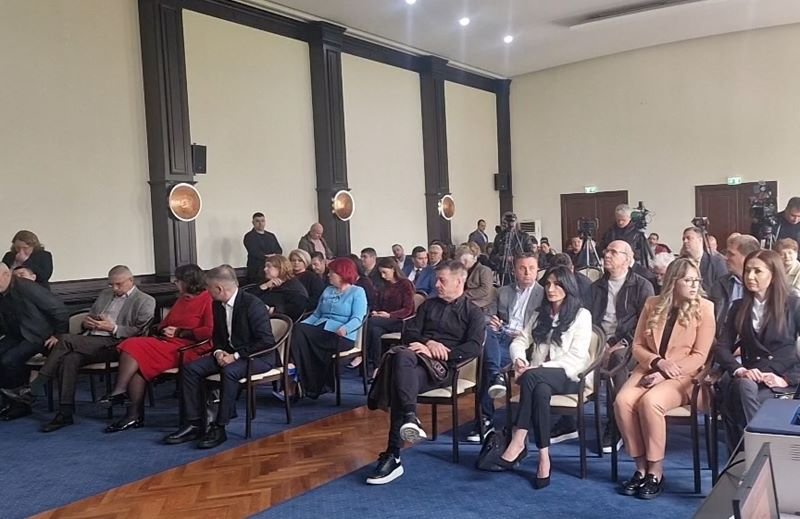 Audience seated in rows in a formal conference room during a presentation/meeting session.