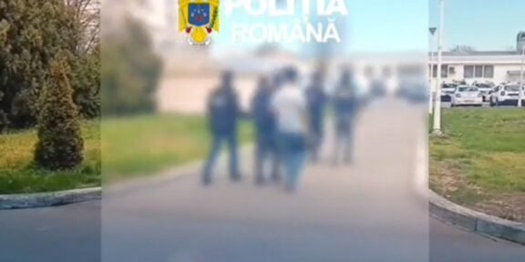 Blurry group of people standing outdoors with the Romanian police emblem in the top-left corner.
