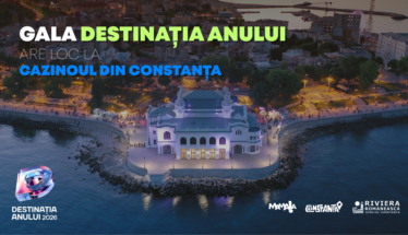 Aerial view of a illuminated casino on a rocky peninsula at dusk promoting Gala Destinația Anului 2026 at the Constanța Casino.