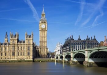 Big Ben (Elizabeth Tower) with the Houses of Parliament and Westminster Bridge across the River Thames on a sunny day in London.