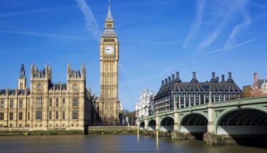 Big Ben (Elizabeth Tower) with the Houses of Parliament and Westminster Bridge across the River Thames on a sunny day in London.