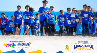 Group of children in blue shirts running on a beach during a marathon, with banners and logos visible in the foreground.