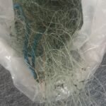 Tangled clear fishing line and a blue braided rope inside a transparent plastic bag