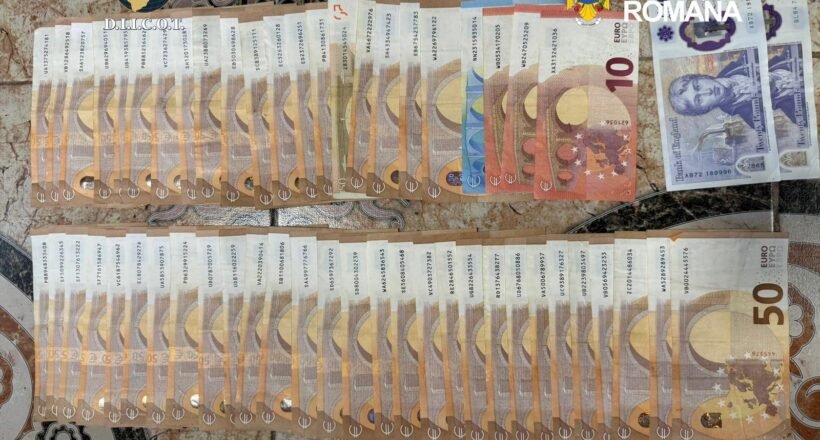Seized euro banknotes arranged in two long rows on a patterned surface, with police logos in the corner.