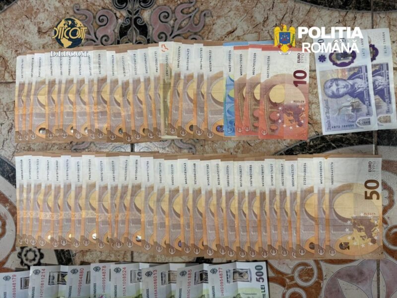 Seized euro banknotes arranged in two long rows on a patterned surface, with police logos in the corner.
