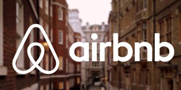 Airbnb logo overlay on a blurred city street background, brand name clearly visible