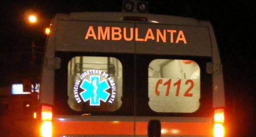 Rear view of a white ambulance at night with orange stripes; 'AMBULANTA' on the back, a blue Star of Life logo, and '112' on the window.