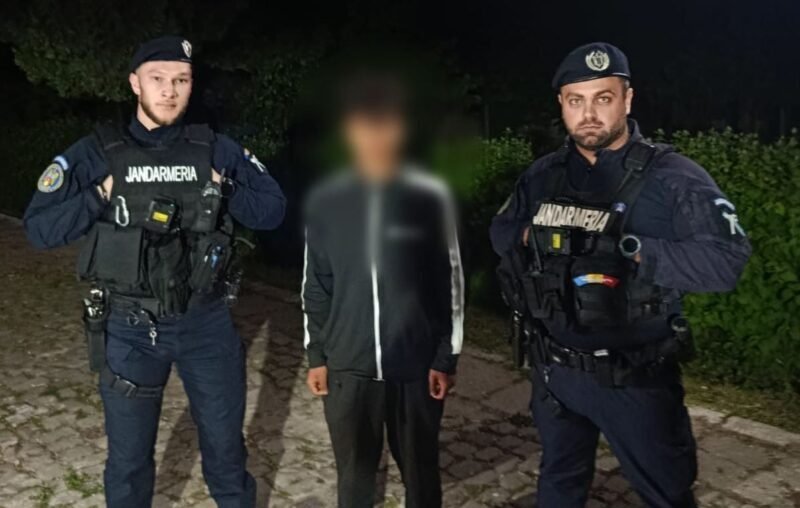 Two gendarmes in tactical gear flank a blurred civilian on a cobblestone path at night.