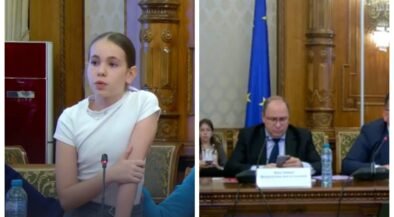 Woman speaking into a microphone at a formal meeting, ornate wood paneling behind her (left).