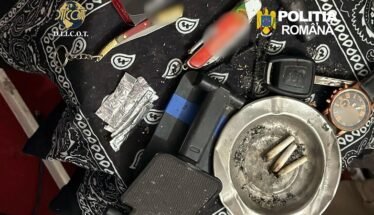 Police evidence photo: cigarette butts in an ashtray, foil packets, a lighter, and other paraphernalia on a patterned cloth with Romanian police logos visible.