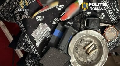 Police evidence photo: cigarette butts in an ashtray, foil packets, a lighter, and other paraphernalia on a patterned cloth with Romanian police logos visible.