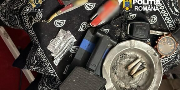 Police evidence photo: cigarette butts in an ashtray, foil packets, a lighter, and other paraphernalia on a patterned cloth with Romanian police logos visible.