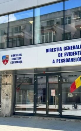 Front of a government building with Romanian flags and a blue sign reading 'Direcția Generală de Evidență a Persoanelor' above the doors (Constanța county office).