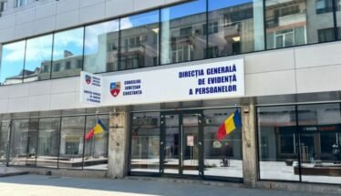 Front of a government building with Romanian flags and a blue sign reading 'Direcția Generală de Evidență a Persoanelor' above the doors (Constanța county office).