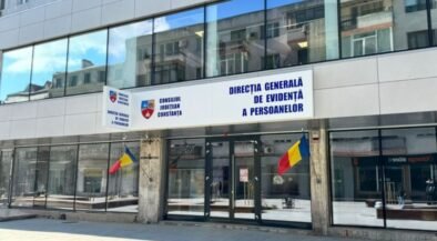Front of a government building with Romanian flags and a blue sign reading 'Direcția Generală de Evidență a Persoanelor' above the doors (Constanța county office).