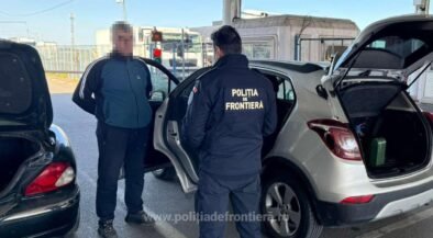 Border police officer in a dark uniform talks to a man at a car with the trunk open at a checkpoint. Frontière police patch visible on the jacket (text: POLIŢIA DE FRONTIERĂ).
