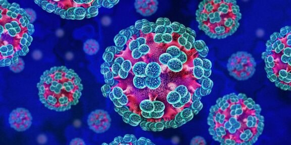 Colorized illustration of multiple spherical viruses with blue spike proteins on a blue background, showing a cluster of coronavirus-like particles.