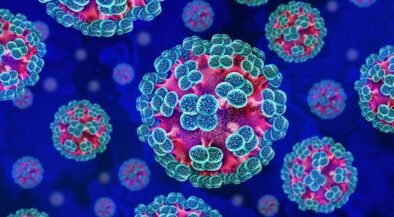 Colorful 3D rendering of multiple coronavirus particles with blue spike proteins on pink-red cores in a dark blue background.