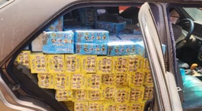 Car trunk loaded with yellow and blue boxed goods stacked to the roof of the cargo area