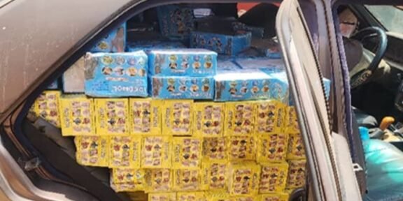 Car trunk loaded with yellow and blue boxed goods stacked to the roof of the cargo area