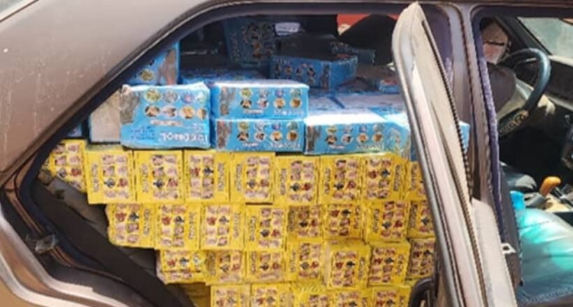 Car trunk loaded with yellow and blue boxed goods stacked to the roof of the cargo area