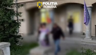 Blurry outdoor scene outside a building with the Romanian Police logo at the top, a European flag on a pole, and several people walking by.