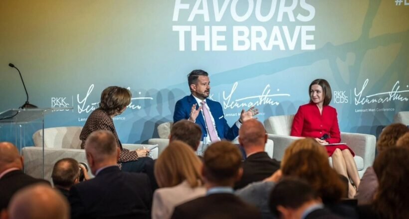 Panel discussion with three speakers on stage; backdrop reads 'Fortune Favours The Brave'.