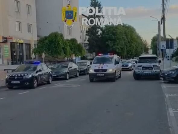 Line of Romanian police cars on a city street with a white van in front and flashing blue lights; 'Politia Romana' watermark and crest visible above.