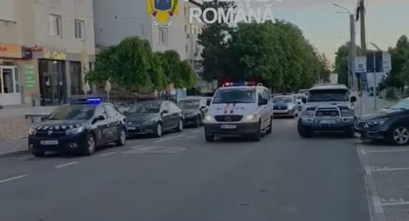 Line of Romanian police cars on a city street with a white van in front and flashing blue lights; 'Politia Romana' watermark and crest visible above.
