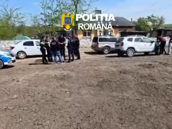 Group of police officers and civilians gathered near parked cars on a dirt lot in a rural area; Romanian police car visible.