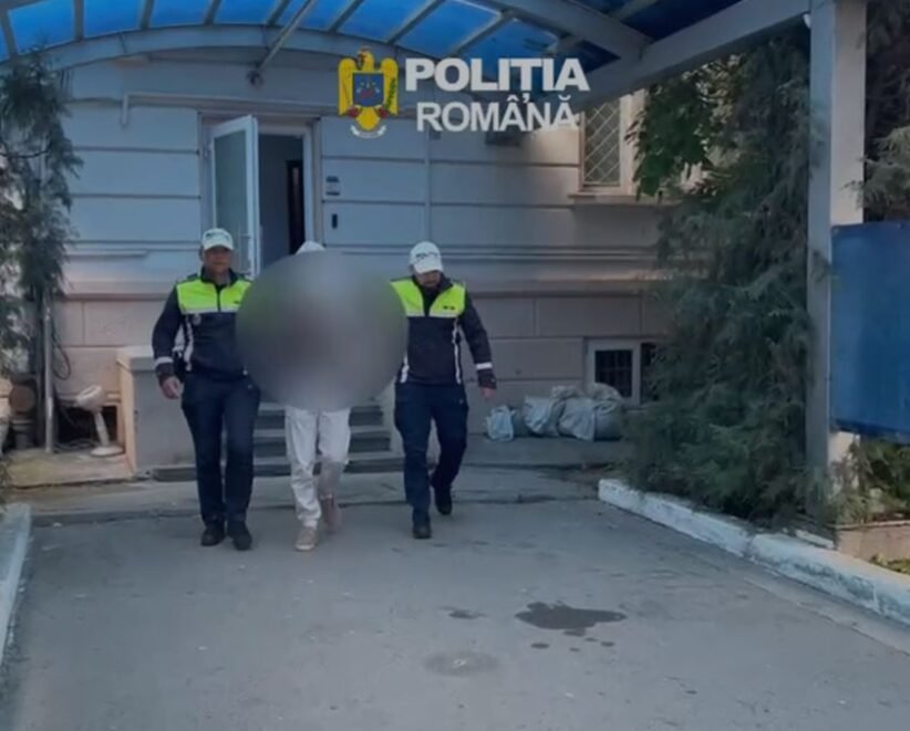 Two Romanian police officers escort a detainee with face blurred outside a building marked Politia Romana.